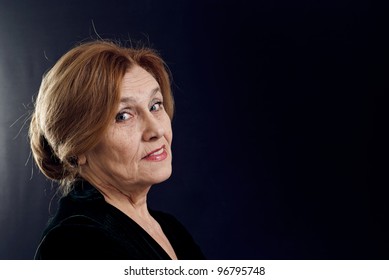 Portrait Of An Elderly Woman On A Dark Background