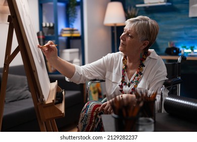 Portrait of elderly woman using wheelchair drawing static nature on easel in home art studio for hobby and recreation. Senior woman relaxing doing pencil sketch of vase model on canvas. - Powered by Shutterstock