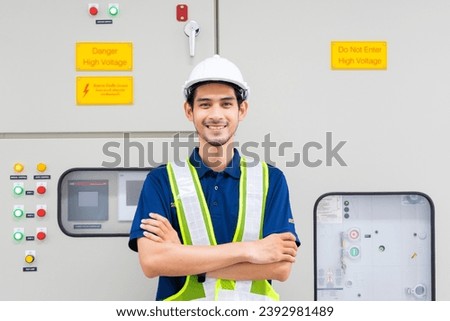 Portrait of Electrical engineer checking Power Distribution Cabinet in the control room. Portrait of Electrical engineer smile and looking at the camera.