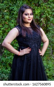 Portrait Of Elegant Indian Female Model Wearing Black Gown , Posing In Summer Green Garden
