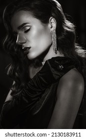 Portrait of elegant woman in vintage retro style of black and white Hollywood film with makeup and hairstyle. Brunette girl with jewelry in noir look