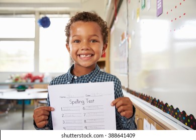 Portrait Of Elementary School Boy Holding Up His Test Paper