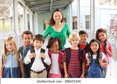 Portrait of elementary school kids and teacher in corridor