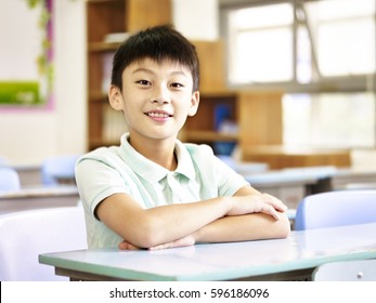 Portrait Of An Eleven-year Old Asian Elementary School Student Sitting In Classroom.