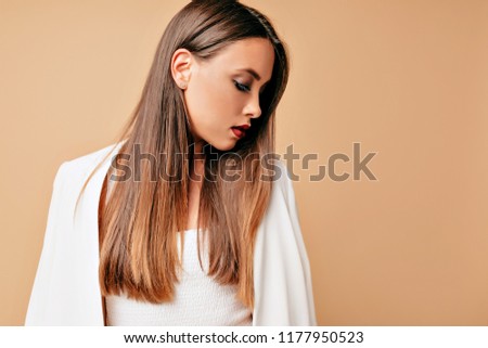 Portrait of ellegant adorable young beautiful woman, isolated over beige background, looking profile, concentrated look. Studio shot beautiful face  caucasian girl with natural make-up, perfect skin  Stock photo © 