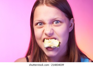 Portrait Of An Emotional Funny Teen Girl Eating Apple