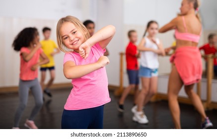 Portrait of emotional girl doing dance workout during group class in studio - Shutterstock ID 2113890650