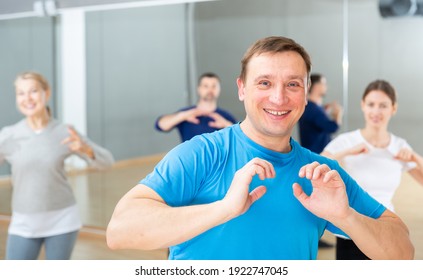 Portrait Of Emotional Man Doing Exercises During Group Class In Dance Center