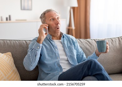 Portrait Of Emotional Surprised Mature Man With Open Mouth Talking On Mobile Phone Sitting On Couch At Home, Drinking Coffee. Shocked Adult Male Speaking, Having Cellphone Conversation Hearing News - Powered by Shutterstock