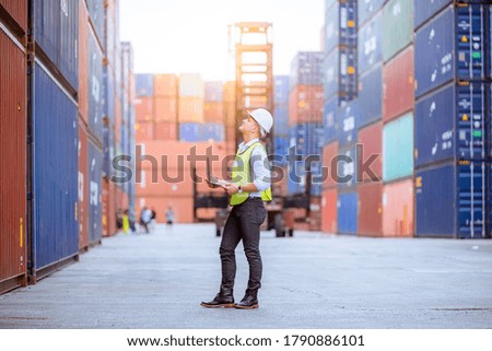 Portrait engineer dock worker under working and checking production process on dock container warehouse and wearing safety uniform.
