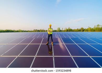 Portrait of engineer man or worker, people, with solar panels or solar cells on the roof in farm. Power plant with green field, renewable energy source in Thailand. Eco technology for electric power. - Shutterstock ID 1593234898