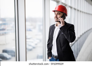 Portrait of an engineer talking on the phone against panoramic windows