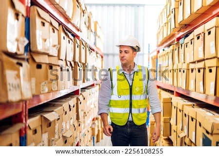 Portrait engineer worker labor man work shipping order detail check goods and supplies on shelves with goods background inventory in factory warehouse.logistic industry and business export