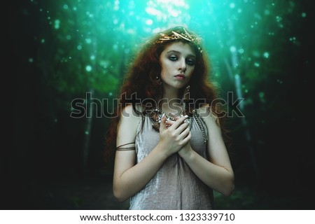 Portrait of a enigmatic beautiful girl posing in a forest. Beauty, fashion. Cosmetics and makeup.