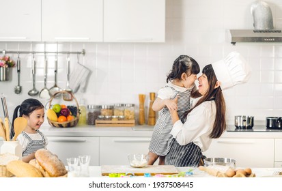 Portrait Of Enjoy Happy Love Asian Family Mother And Little Toddler Asian Girl Daughter Child Having Fun Cooking Together With Baking Cookie And Cake Ingredient On Table In Kitchen