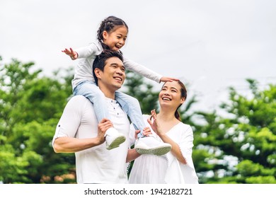 Portrait of enjoy happy love asian family father and mother holding cute little asian girl child smiling playing and having fun moments good time in summer park at home - Shutterstock ID 1942182721