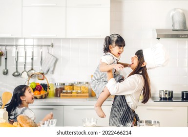 Portrait Of Enjoy Happy Love Asian Family Mother And Little Toddler Asian Girl Daughter Child Having Fun Cooking Together With Dough For Homemade Bake Cookie And Cake Ingredient On Table In Kitchen