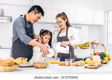 Portrait Of Enjoy Happy Love Asian Family Father And Mother With Little Asian Girl Daughter Child Play And Having Fun Cooking Food Together With Baking Cookie And Cake Ingredient In Kitchen