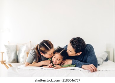 Portrait Of Enjoy Happy Love Asian Family Father And Mother Holding Hug Cute Little Asian Girl Child Smiling Play And Having Fun Moments Good Time In At Home	