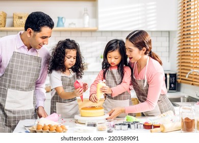 Portrait Of Enjoy Happy Love Asian Family Father And Mother With Little Asian Girl Daughter Child Play And Having Fun Cooking Food Together With Baking Cookie And Cake Ingredient In Kitchen