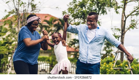 Portrait of enjoy happy love black family african american father and mother holding little african girl hand in moments good time in summer park at home - Powered by Shutterstock