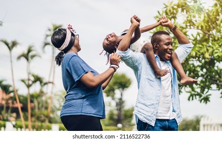 Portrait Of Enjoy Happy Love Black Family African American Father And Mother With Little African Girl Child Smiling And Play Having Fun Moments Good Time In Park At Home