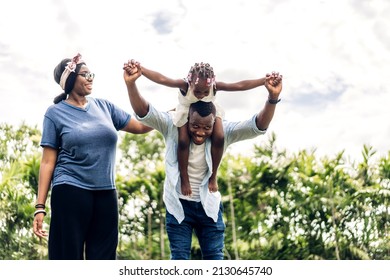 Portrait Of Enjoy Happy Love Black Family African American Father And Mother With Little African Girl Child Smiling And Play Having Fun Moments Good Time In Park At Home