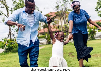 Portrait Of Enjoy Happy Love Black Family African American Father And Mother With Little African Girl Child Smiling And Play Having Fun Moments Good Time In Room At Home