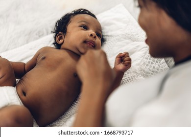 Portrait Of Enjoy Happy Love Family African American Mother Playing With Adorable Little African American Baby.Mom Touching With Cute Son Moments Good Time In A White Bedroom.