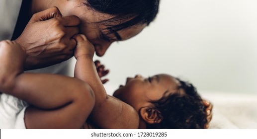 Retrato de desfrutar feliz amor família afro-americana mãe brincando com adorável bebê afro-americano.Mãe tocando com filho bonito momentos bom tempo em um quarto branco.Amor da família negra 
