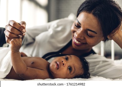 Portrait Of Enjoy Happy Love Family African American Mother Playing With Adorable Little African American Baby.Mom Touching With Cute Son Moments Good Time In A White Bedroom.Love Of Black Family 