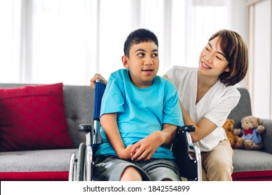 Portrait Of Enjoy Happy Love Family Asian Mother Playing And Carer Helping Look At Disabled Son Child Sitting In Wheelchair Moments Good Time At Home.disability Care Concept