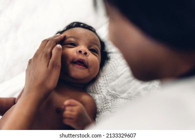 Portrait Of Enjoy Happy Love Family African American Mother Playing With Adorable Little African American Baby.Mom Kiss With Cute Son Moments Good Time In A White Bedroom.Love Of Black Family