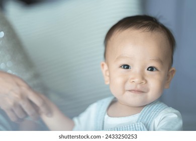 Portrait of enjoy happy love family asian mother playing with adorable little asian baby newborn infant, Mom touching care with cute son in a white bedroom.Love of family concept - Powered by Shutterstock