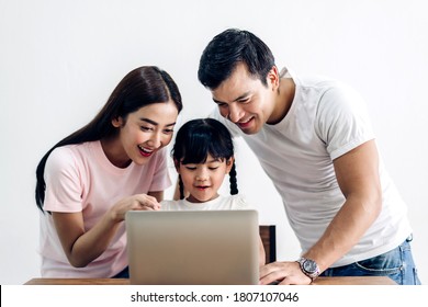 Portrait Enjoy Happy Smiling Love Asian Family Father And Mother With Little Asian Girl Learning And Looking At Laptop Computer Studying With Online Education E-learning System With Teacher At Home