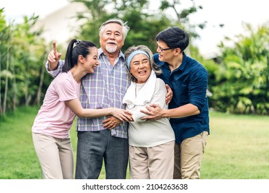 Portrait Enjoy Happy Smiling Love Multi-generation Asian Big Hug Family.Senior Mature Father And Elderly Mother With Young Adult Woman And Son Outdoor In Park At Home.insurance Concept