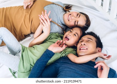 Portrait Enjoy Happy Smiling Love Asian Family Father And Mother With Young Parents Little Child Asian Girl Daughter Play And Looking Together In Moments Good Time Lying On The Bed At Home