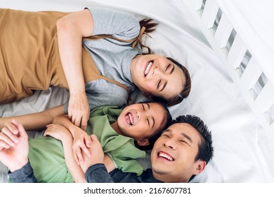 Portrait Enjoy Happy Smiling Love Asian Family Father And Mother With Young Parents Little Child Asian Girl Daughter Play And Looking Together In Moments Good Time Lying On The Bed At Home