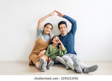 Portrait Enjoy Happy Smiling Love Asian Family Father And Mother With Young Parents Little Asian Girl Sitting And Making Roof House With Hands Arms Over Head In New Home