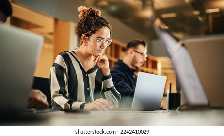 Portrait of Enthusiastic Hispanic Young Woman Working on Computer in a Modern Bright Office. Confident Human Resources Agent Smiling Happily While Collaborating Online with Colleagues. - Shutterstock ID 2242410029