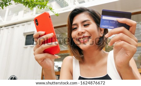 Portrait entrepreneur pretty asian woman wearing office clothing feeling happy and smile hands holding credit card and touching screen on smart phone mobile, Credits card Payment shopping lifestyles.