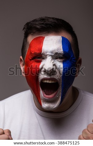 Portrait Euphoric scream of France football fan in win game of France national  team  on grey background. European  football fans concept.