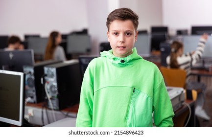 Portrait Of European Teenager Boy Standing In Computer Class.