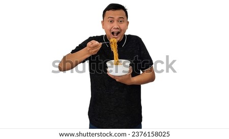 Portrait of excited Asian man casual shirt eating instant noodles, asian man eating noodles, happy asian man or indonesian man eating instant noodles with hand delicious gesturing 