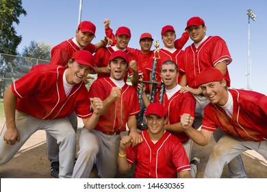 Portrait Of Excited Baseball Team Holding Trophy With Pride