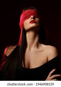 Portrait Of Excited Brunette Woman Wearing Off-shoulder Dress Holds Head Up With Her Eyes Covered With Scarf, Blindfold Over Black Background. Fashion, Vogue, Sexy Stylish Look For Woman Concept