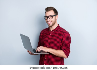 Portrait Of Excited Confident With Beaming Toothy Smile Wearing Red Checkered Shirt With Rolled-up Sleeves With Bristle Guy Using Laptop For Developing New Project, Isolated On Gray Background