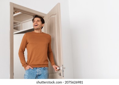 Portrait of excited emotional man walking in his apartment, entering new home, happy young guy standing in doorway of modern flat, looking at design interior, coming inside, free copy space - Shutterstock ID 2075626981