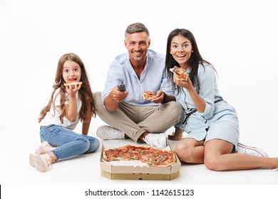 Portrait Of An Excited Family Father, Mother, Little Daughter Having Fun While Eating Pizza And Watching TV Isolated Over Gray Background