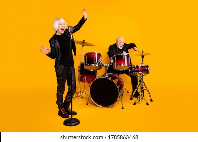 Portrait of excited grey-haired couple performing singing playing live sound isolated over bright vivid shine vibrant yellow color background